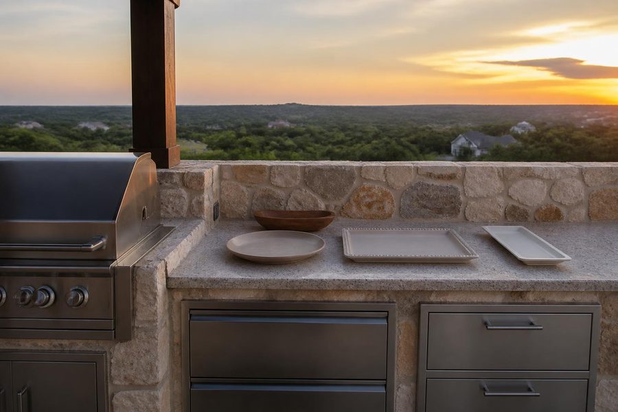 Outdoor kitchen cabinets with open counter space set up for serving food to guests on a Central Florida patio in the evening